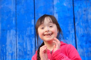 Young girl smiling on background of the blue wall